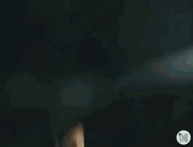 a blurry picture of a man in a white vest jumping in the air .
