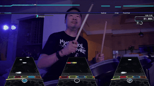 a man in a my chemical romance shirt plays drums