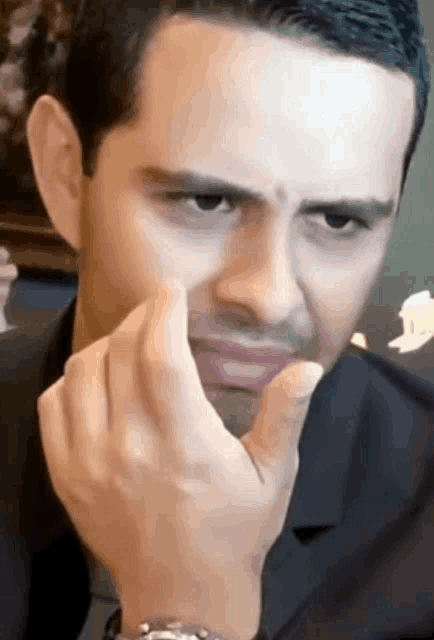 a man wearing a watch making a face with his hand