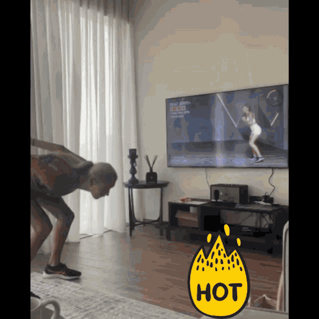 a woman is doing exercises in front of a television with a hot sticker on it