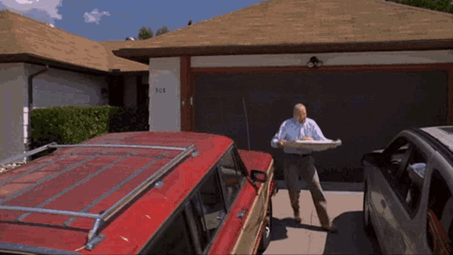 a man is standing in front of a red suv with the number 708 on it