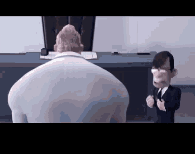 a man in a suit and tie is talking to another man in a suit and tie