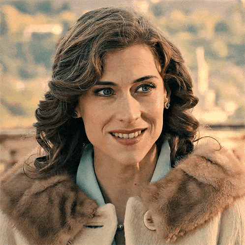 a woman is wearing a fur coat and smiling for the camera