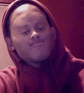 a man wearing a red hoodie is smiling