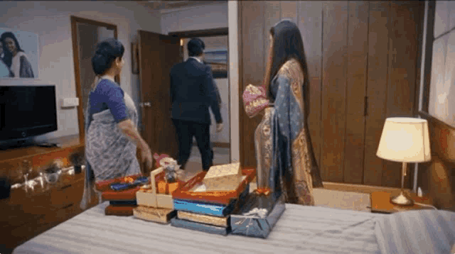 a man in a suit and a woman in a saree are standing in a room