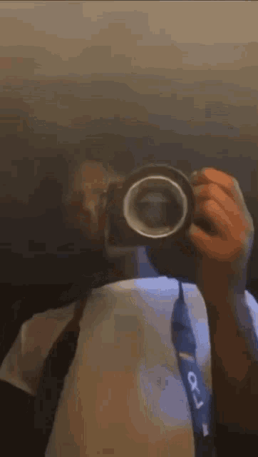 a person is taking a picture of themselves with a camera with a strap that says ' x1 ' on it