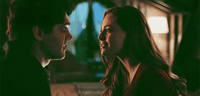 a man and a woman are looking at each other in a room .
