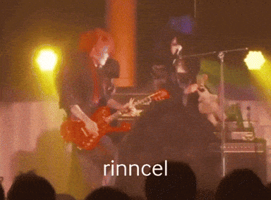 a man playing a guitar on stage with the word rincel in the foreground