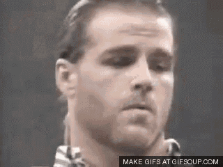a close up of a man 's face with his eyes closed and a ponytail .