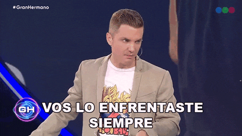 a man in a suit stands in front of a screen that says " vos lo enfrentaste siempre "