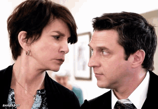 a man and a woman are looking at each other with the barbabot logo in the corner