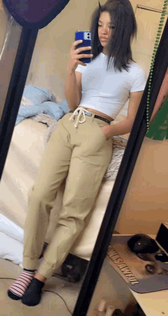 a girl is taking a selfie in front of a mirror with the letter b on the phone