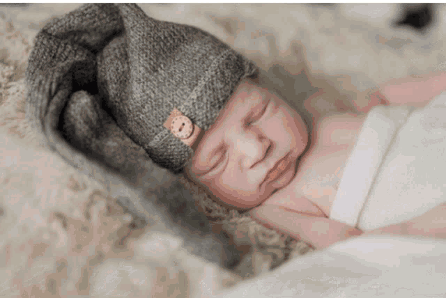 a newborn baby wearing a knitted hat with buttons on it