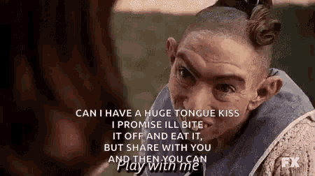a man with a shaved head is talking to a woman with a huge tongue kiss .
