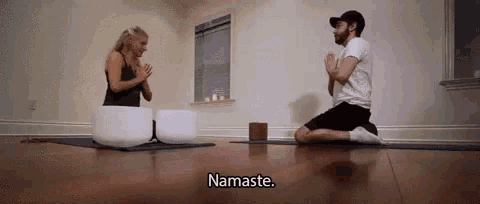 a man and a woman are kneeling on a yoga mat and praying .