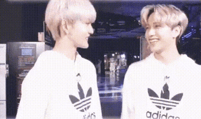 a couple of boys are standing next to each other and looking at each other .