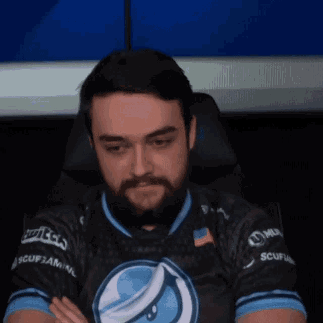 a man with a beard wearing a shirt that says scuf gaming