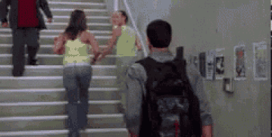 a man with a backpack is walking down stairs with a woman