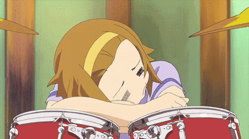 a girl laying on top of a drum set with a yellow headband