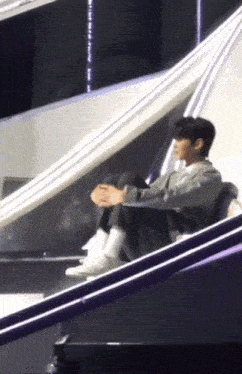 a person is sitting on a staircase with their legs crossed .