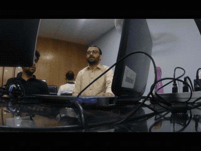 a man stands in front of a laptop that has a label on it that says ' lenovo '