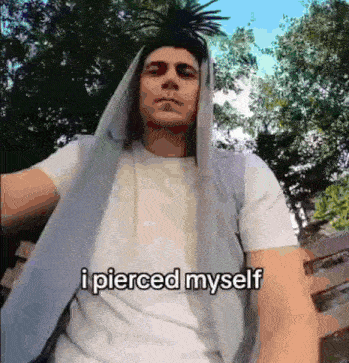a man is wearing a hooded jacket and a white shirt and says i pierced myself .