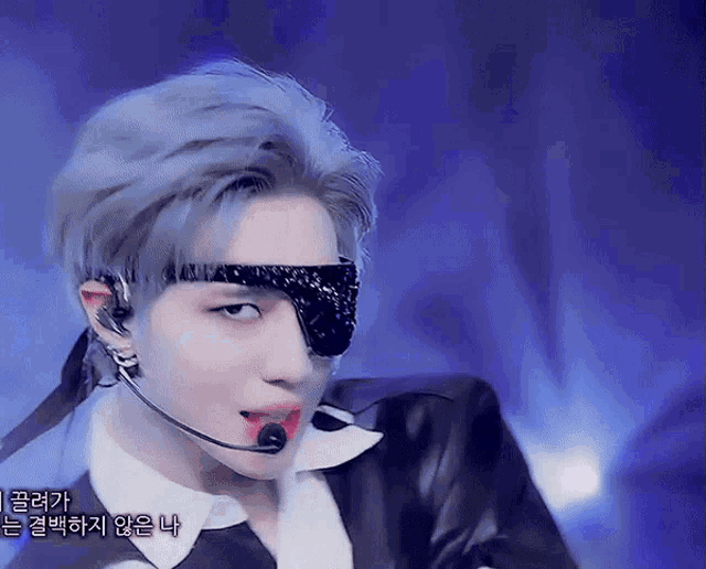 a man wearing a mask and a microphone has korean writing on his face