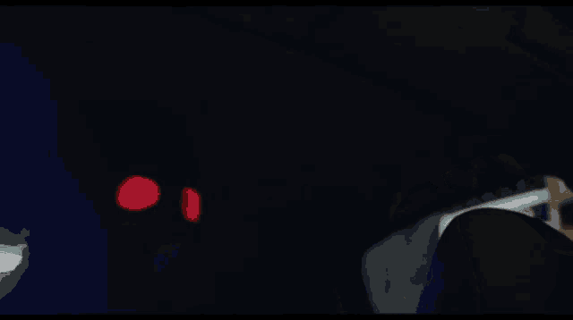 a man holding a gun to his head with a red light in the background
