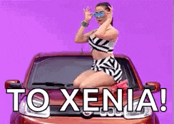 a woman is sitting on the hood of a car with the words to xenia written on it .
