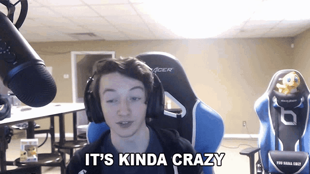 a young man wearing headphones says it 's kinda crazy in front of a microphone