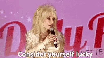 dolly parton is singing into a microphone and saying consider yourself lucky .