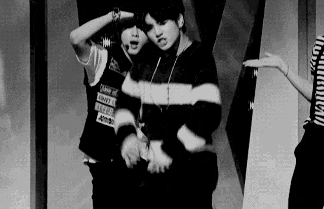 a black and white photo of a couple of men dancing on a stage .