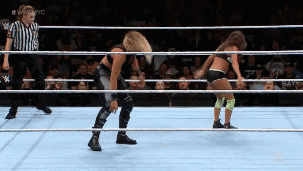 two women are wrestling in a ring with a referee in the background and the words wwnyc on the bottom
