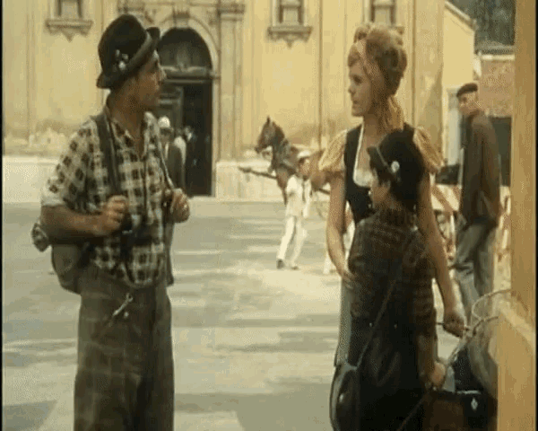 a man in a plaid shirt is talking to two women