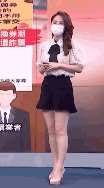 a woman wearing a mask is standing in front of a sign with chinese writing