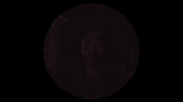 a girl in a black jacket with the letter m on it is surrounded by people