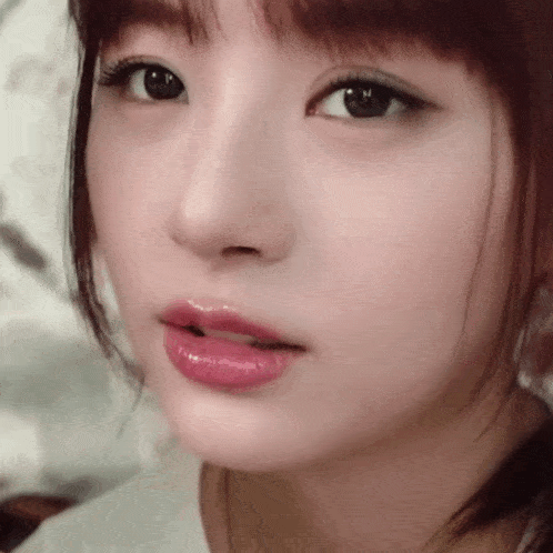 a close up of a woman 's face with a white shirt on