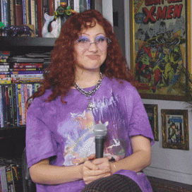 a woman in a purple shirt is holding a microphone