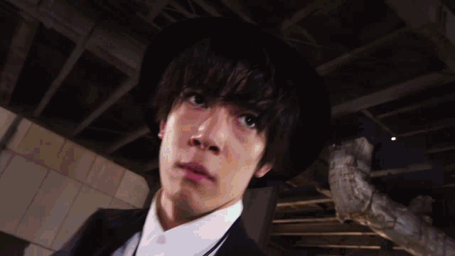 a young man wearing a black hat and a white shirt looks up
