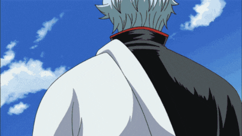 a man with gray hair and a black jacket looks at the sky