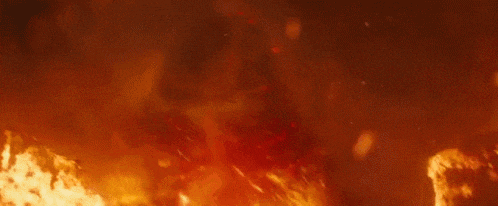 a large fire is burning in the dark with smoke coming out of it .