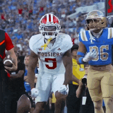 a football player for the hoosier 's is running with the ball