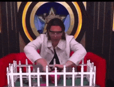 a woman wearing goggles is sitting in front of a white fence