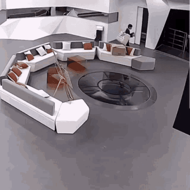 a man is standing in a room with a lot of couch 's and tables