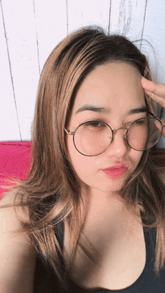a woman wearing glasses is taking a selfie