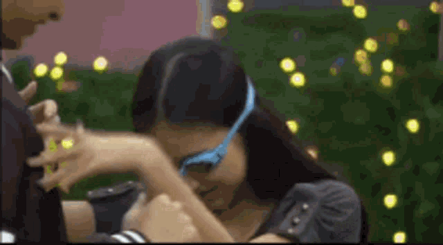 a woman wearing blue glasses is being held by a man
