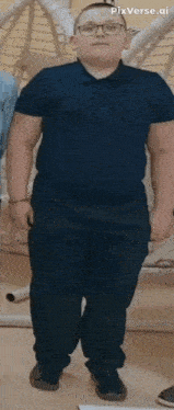 a man wearing a blue shirt and black pants is standing in front of a hammock .