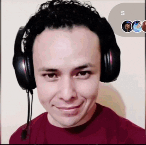 a man wearing headphones and a red shirt with the letter s on the bottom right
