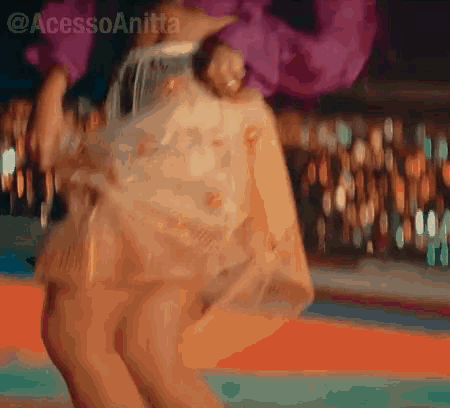 a woman in a purple dress is dancing in front of a crowd of people .