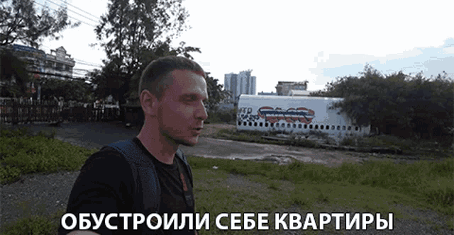 a man stands in front of an airplane with graffiti on it and a sign that says " obystroili sebe kvartiry "